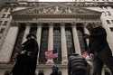 People walk past the New York Stock Exchange, December 11, 2023, in New York